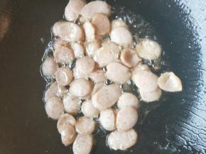 油锅热油，先放入香肠，翻炒到发白