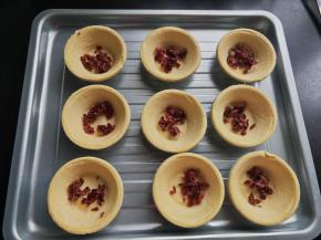 将蔓越莓放入蛋挞皮中。
