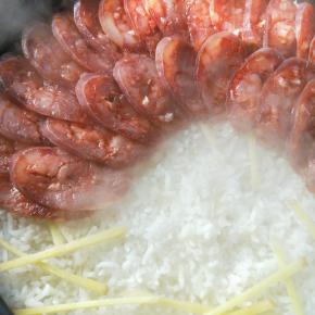 米煮至八成熟的时候，撒上姜丝，然后铺上香肠，盖上盖子小火焖7分钟。