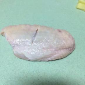 首先鸡翅洗干净后，在鸡背上划两刀，这样有利于去血水，腌制也更入味