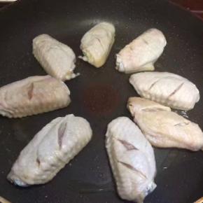 锅中放入油，八成热时放入鸡翅，小火慢煎，在鸡翅煎的过程中会出一部分油，所以开始不需要加太多油