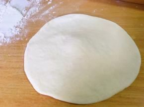 取一个面球，擀成中间厚四周略薄的小饼。