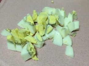 熟鸡蛋切成小块，可以把菜刀在水里沾一下水后切鸡蛋，这样避免鸡蛋黄沾到刀面上不好切。
