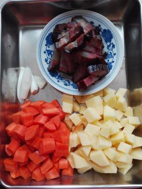 胡萝卜、土豆去皮洗净切丁，蒸好的腊肉切片