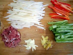 将莲藕去皮切丝，在冷水中浸泡两遍捞起备用。青、红辣椒切丝、瘦肉切丝、姜蒜切片。