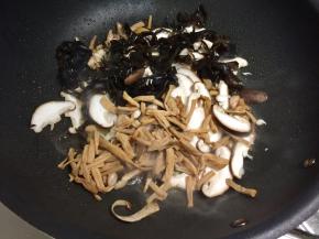 加入香菇、木耳和黄花菜接着炒。