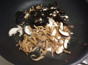 加入香菇、木耳和黄花菜接着炒。