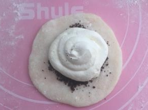 擀开成圆片，放适量饼干粉，上面挤一圈淡奶油