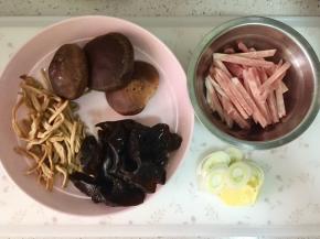 把木耳和黄花菜提前泡发，木耳洗净，黄花菜挤干水分。香菇洗净，猪肉切成条，冻的比较好切，大葱和生姜切片。