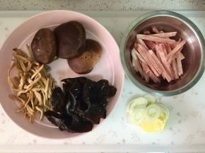 把木耳和黄花菜提前泡发，木耳洗净，黄花菜挤干水分。香菇洗净，猪肉切成条，冻的比较好切，大葱和生姜切片。