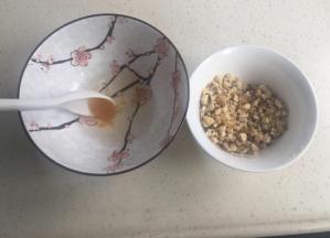 烤箱预热上下火180度。把辅料里的蜂蜜和水调匀。核桃仁切碎