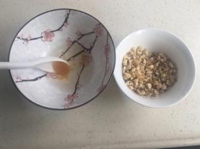 烤箱预热上下火180度。把辅料里的蜂蜜和水调匀。核桃仁切碎