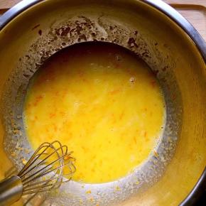 蛋黄中加入橙皮屑（刮皮有专用工具，这一步漏拍了）加入橙汁和玉米油的混合物搅拌至完全融合