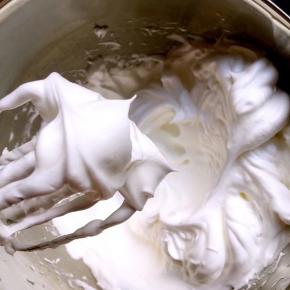 蛋白中加入剩下的糖打发至如图提起打蛋器蛋白呈坚挺的小角（此时烤箱也开始预热）