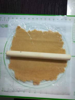 取出，底下垫油纸，上面盖一层保鲜膜，开始用擀面杖把它擀成薄片。厚度大概4，5毫米吧