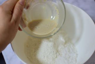 酵母放在温水中拌匀，面粉和白糖放在一起，把酵母水缓慢倒入面粉中