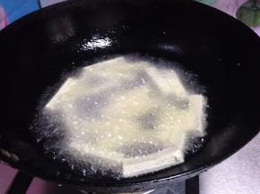 锅内加油烧热至5、6成热，下入豆腐条