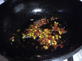 加入葱、蒜碎炒出香味，烹入料酒去除豆腥味