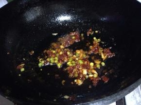 加入葱、蒜碎炒出香味，烹入料酒去除豆腥味