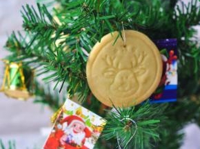 等饼干晾凉后再移动，用棉线穿过饼干上面的小洞，绑在圣诞树上。