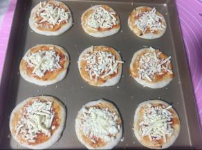 先刷披萨酱，放奶酪碎。