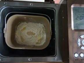 加入奶粉、面粉和切成小块的黄油，在面粉顶端加入酵母