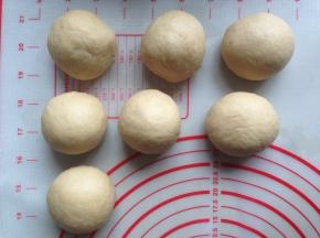 将面团取出，用手掌压出面团内的气体，分成7份，盖上保鲜膜，松驰20分钟