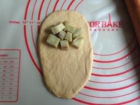 将面团擀成椭圆形，放上蒸熟的红薯块