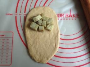 将面团擀成椭圆形，放上蒸熟的红薯块