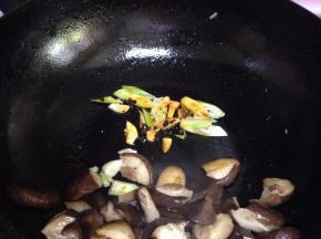 把香菇片拨到一边，小火下入葱、蒜、油豆豉炒出香味，烹料酒去腥