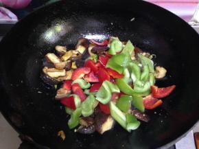 倒入青、红椒片，加入生抽、糖调味