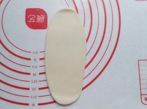取一份静置好的面团擀开，擀成长随圆形，尽量稍长些，起酥效果也会更好些；