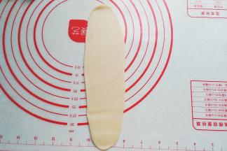 再次擀开擀长，这次面皮的宽度要比先前窄一点；