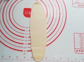 再次擀开擀长，这次面皮的宽度要比先前窄一点；
