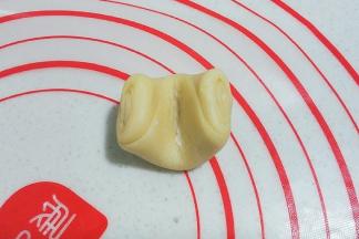 静置好后，取一份面团，先用手指在中间按压一下；