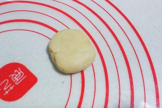 再用手掌压扁，然后擀成圆形，边缘稍擀薄些；