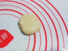 再用手掌压扁，然后擀成圆形，边缘稍擀薄些；