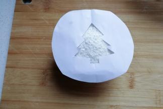 将漏空纸放在撒好的蛋糕椰蓉表面上；