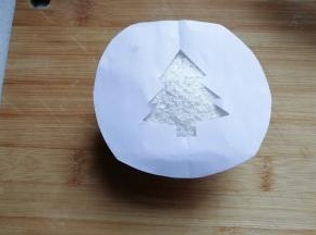 将漏空纸放在撒好的蛋糕椰蓉表面上；