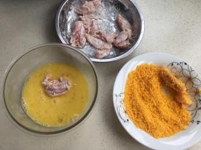 这边把鸡肉沾淀粉，然后裹蛋液，最后沾面包糠