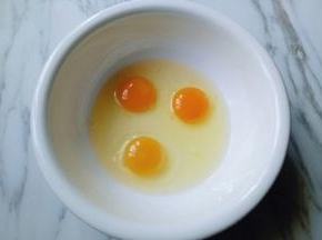 鸡蛋打入大口碗中，用手动打蛋器打散。
