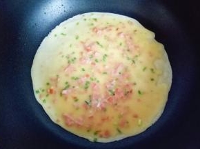 平底锅加热，刷上一层食用油。热锅中，盛两勺面糊，拿起平底锅摇晃一圈，再用勺子底部将面糊摊平。 小火煎至鸡蛋饼表面的蛋液凝固即可。