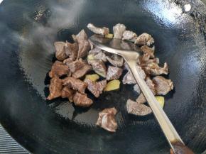 倒入牛肉，放料酒，盐，酱油，翻炒均匀。