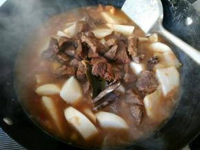 倒入烧好的牛肉，大火烧开，转小火慢炖。