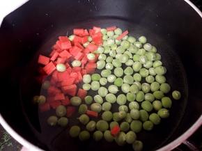 将胡萝卜切小丁和豌豆一起下锅煮熟。