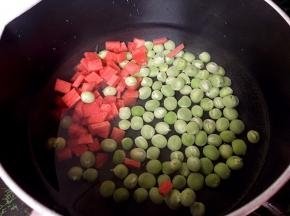 将胡萝卜切小丁和豌豆一起下锅煮熟。