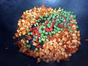 倒入煮熟的胡萝卜和豌豆翻炒均匀。