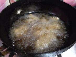 锅内加油烧至4、5成热，分次放入羊肉丁炸制