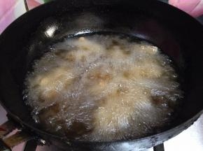 锅内加油烧至4、5成热，分次放入羊肉丁炸制