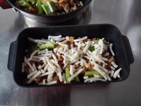 拌匀的米饭扑入土司盒中，上面铺一层奶酪丝